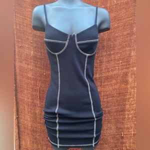 Black fitted mini dress with white stitching.